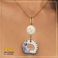 استایل گردنبند مروارید باروک و پلاک سرامیکی آبی کبالتی کد RCGA038 برند میلوارا روی گردن مدل زنانه